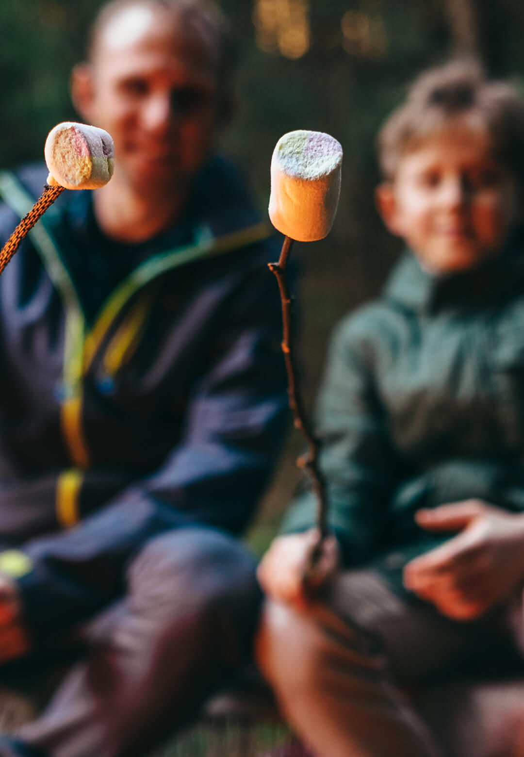 Father and Son roasting marshmallows while camping